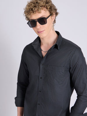 Man wearing a dark steel blue micro checkered shirt .