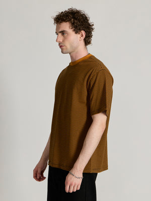 Man wearing a mustard yellow and black striped crew t-shirt