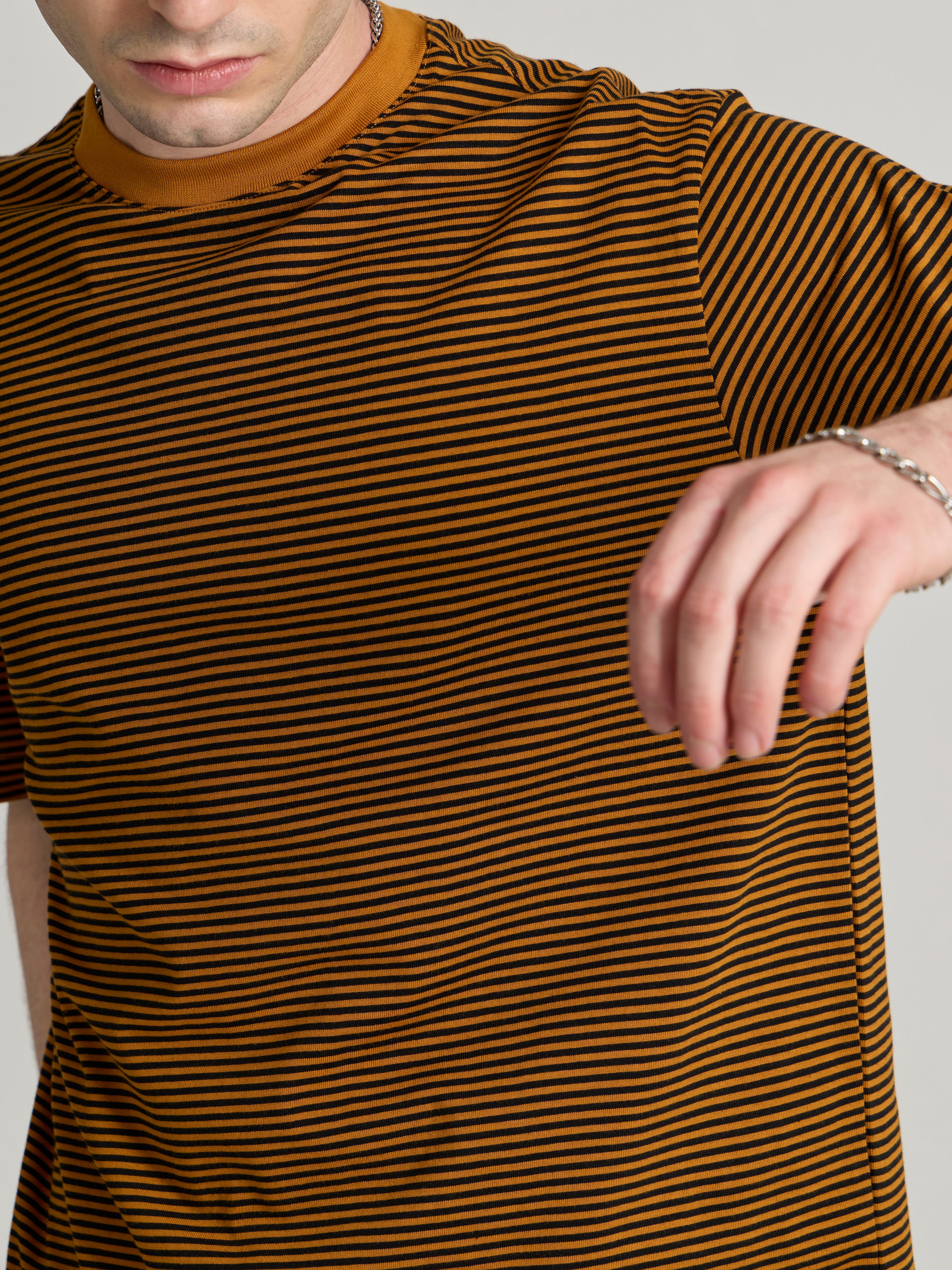 Man wearing a mustard yellow and black striped crew t-shirt