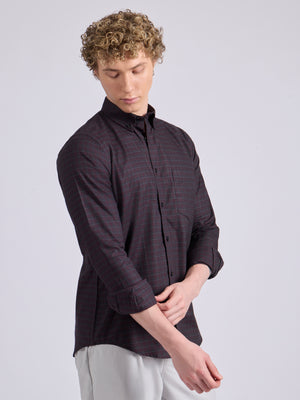 Man wearing a dark burgundy checkered shirt.