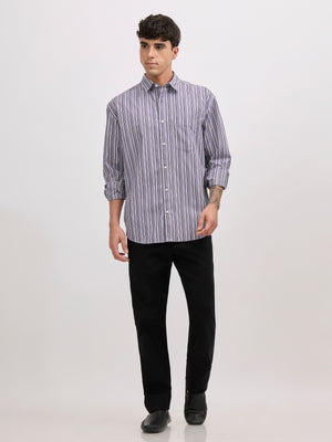 Man wearing an indigo color cotton oversized striped shirt with rolled sleeves, front pocket, and button-down collar
100% cotton