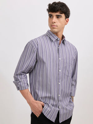 Man wearing an indigo color cotton oversized striped shirt with rolled sleeves, front pocket, and button-down collar
100% cotton.