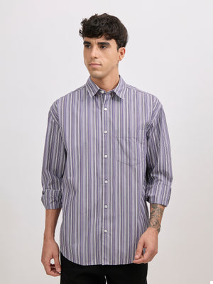 Man wearing an indigo color cotton oversized striped shirt with rolled sleeves, front pocket, and button-down collar
100% cotton