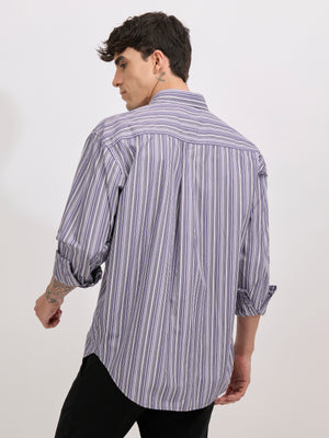 Man wearing an indigo color cotton oversized striped shirt with rolled sleeves, front pocket, and button-down collar
100% cotton