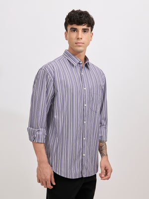 Man wearing an indigo color cotton oversized striped shirt with rolled sleeves, front pocket, and button-down collar
100% cotton