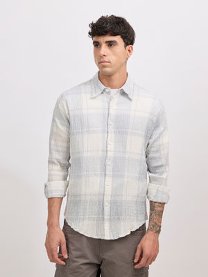 Men's oversized pale blue checkered cotton shirt with full sleeves, styled with grey trousers – casual fashion look