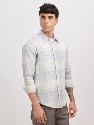 Men's oversized pale blue checkered cotton shirt with full sleeves, styled with grey trousers – casual fashion look