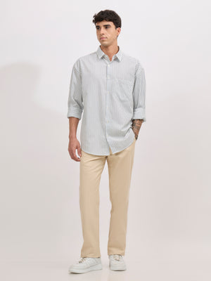 Man wearing a blue cotton oversized striped shirt with rolled sleeves, front pocket, and button-down collar
100% cotton