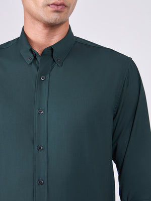 Man wearing Tencel prussian blue shirt and light gray pants on a white background