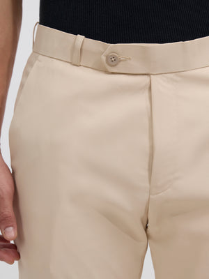 men's sand beige skinny fit trousers blended with polyster and spandex - paired with a black top and black shoes.