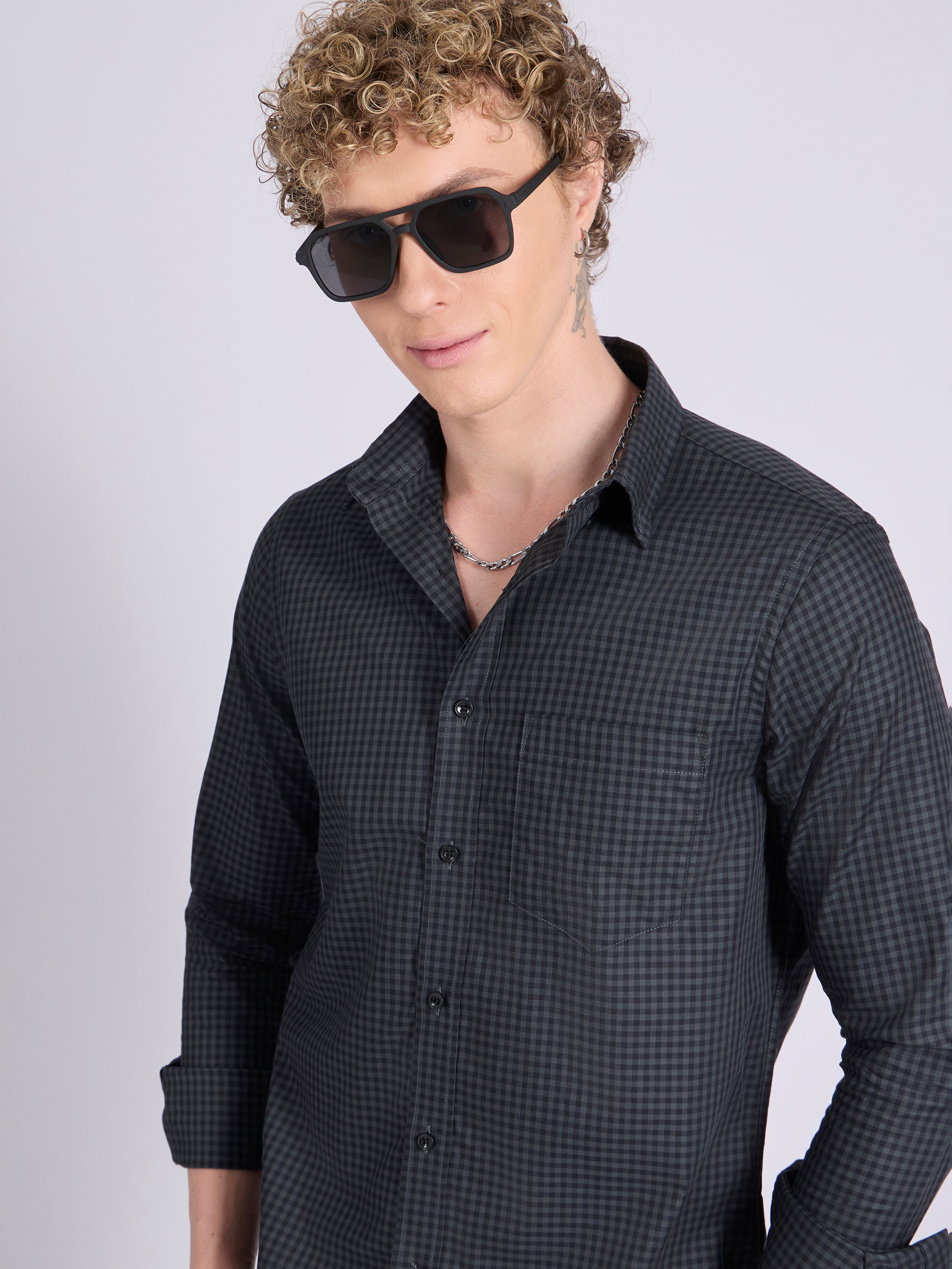 Man wearing a dark steel blue micro checkered shirt .
