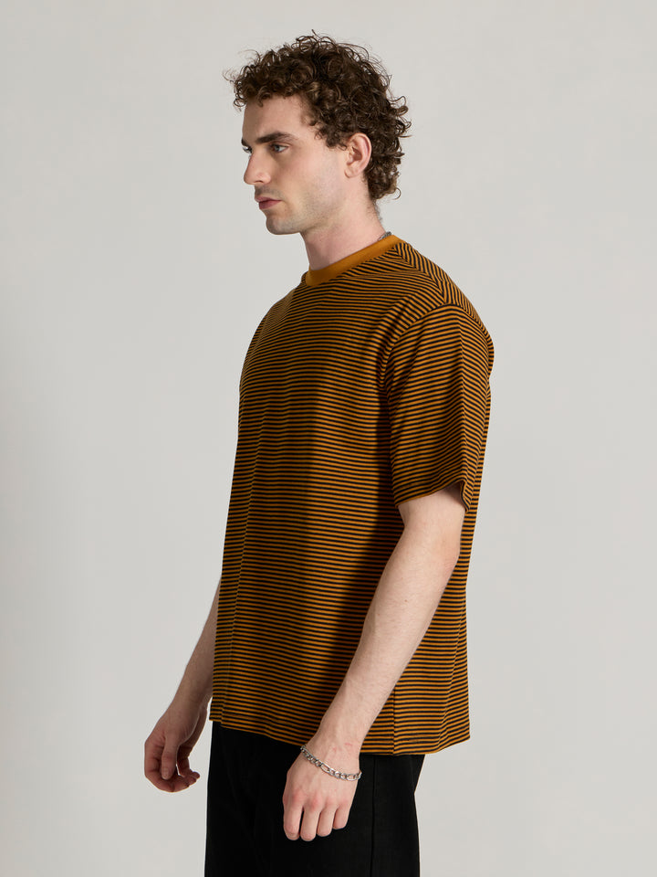 Man wearing a mustard yellow and black striped crew t-shirt 
