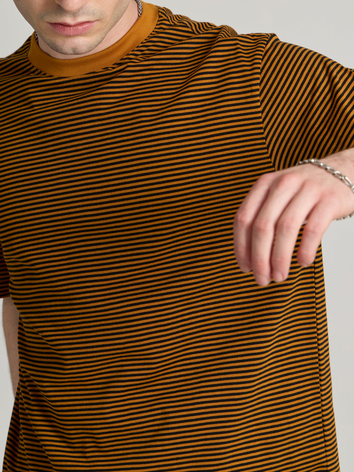 Man wearing a mustard yellow and black striped crew t-shirt 
