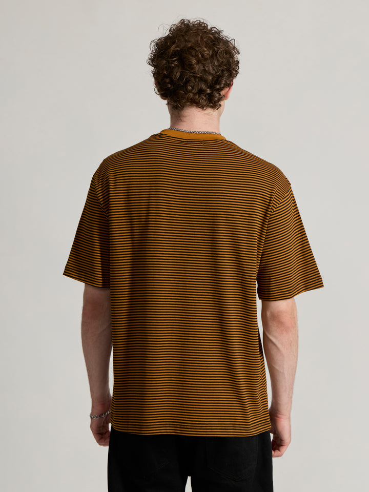 Man wearing a mustard yellow and black striped crew t-shirt 
