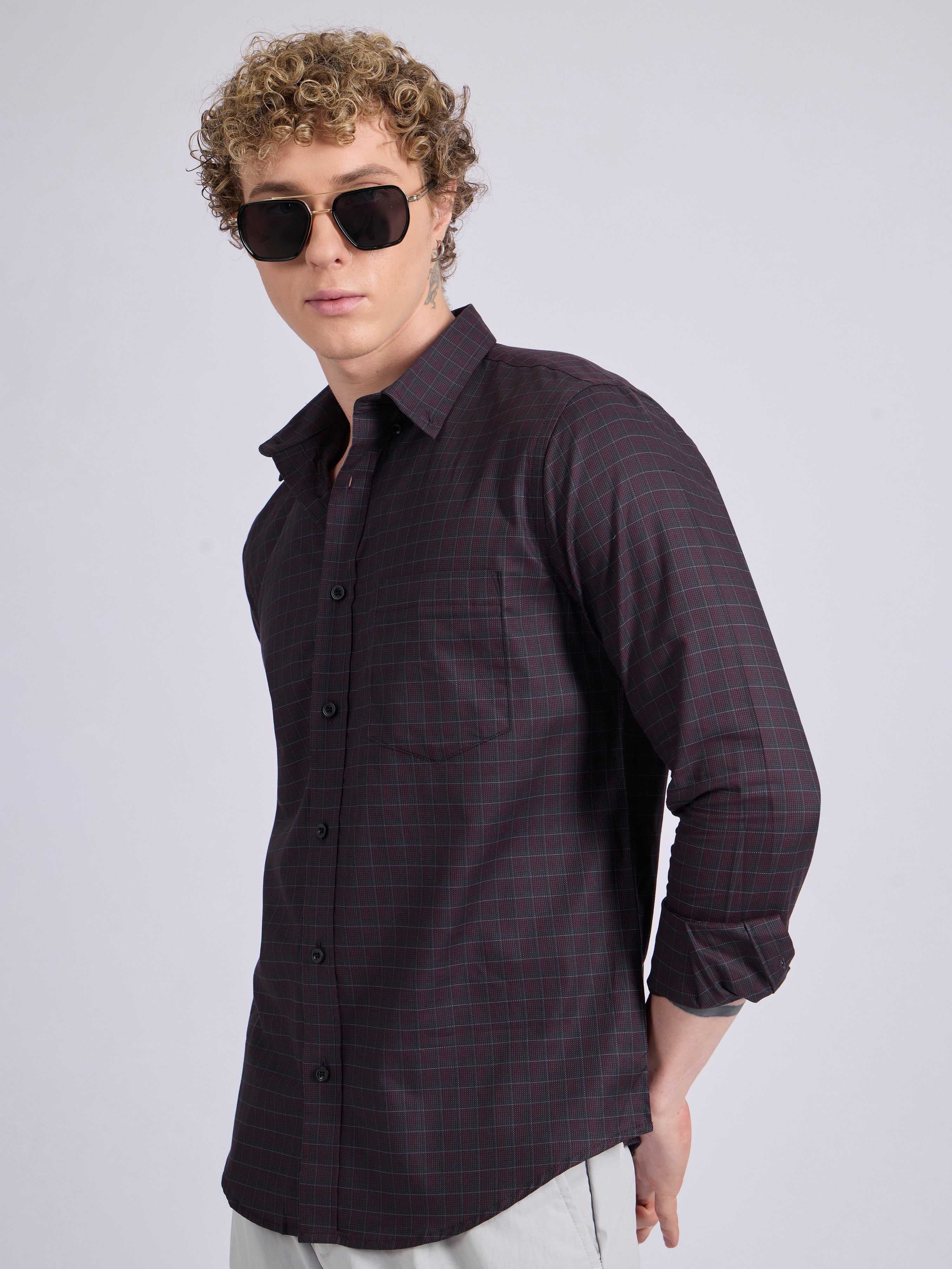 Man wearing a dark burgundy checkered shirt.