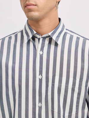 Man wearing a monochrome cotton oversized striped shirt with rolled sleeves, front pocket, and button-down collar
100% cotton
