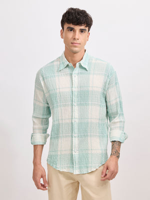 Men's oversized pale green checkered cotton shirt with full sleeves, styled with beige trousers – casual fashion look