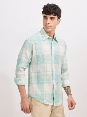 Men's oversized pale green checkered cotton shirt with full sleeves, styled with beige trousers – casual fashion look