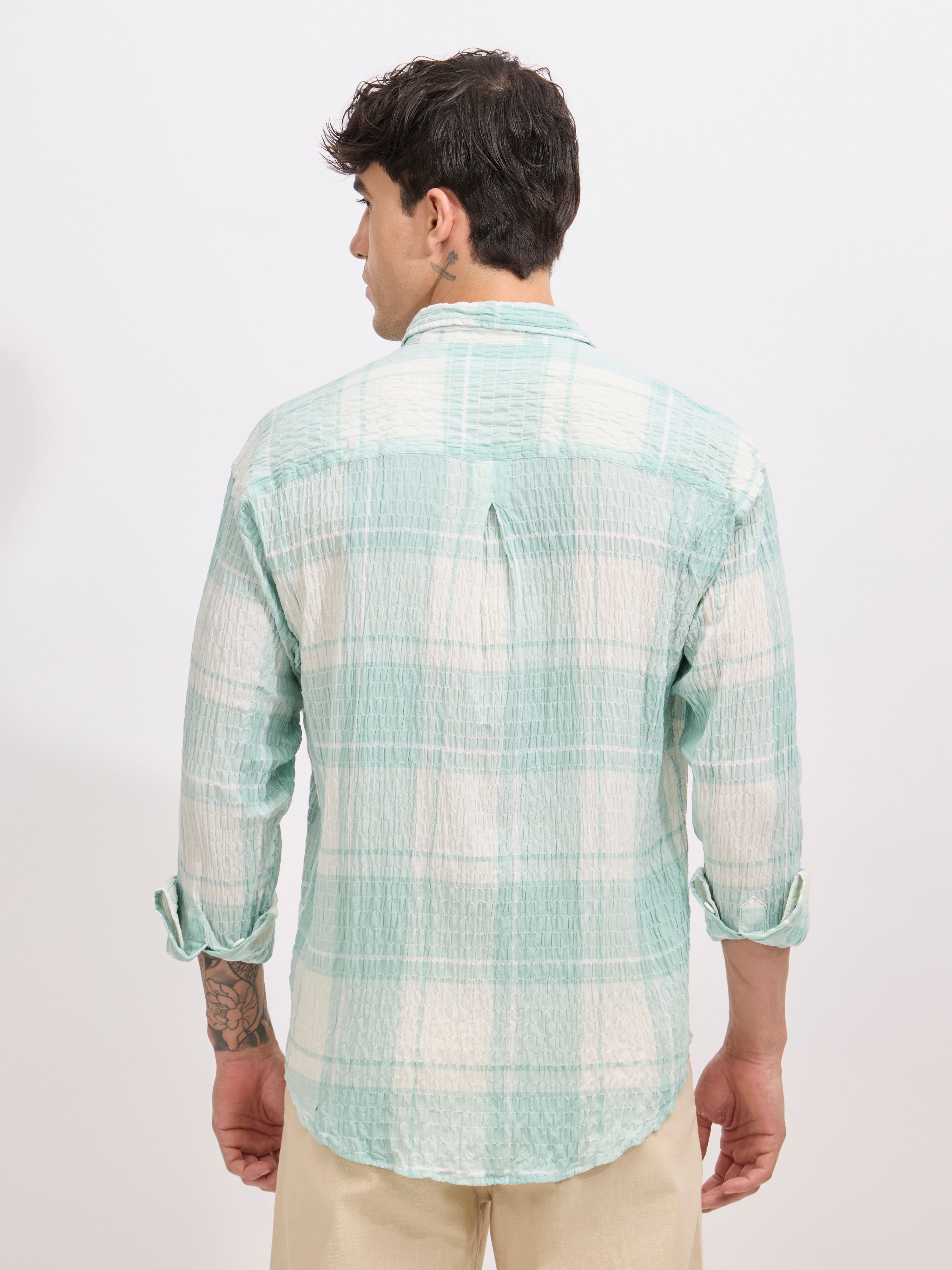 Men's oversized pale green checkered cotton shirt with full sleeves, styled with beige trousers – casual fashion look