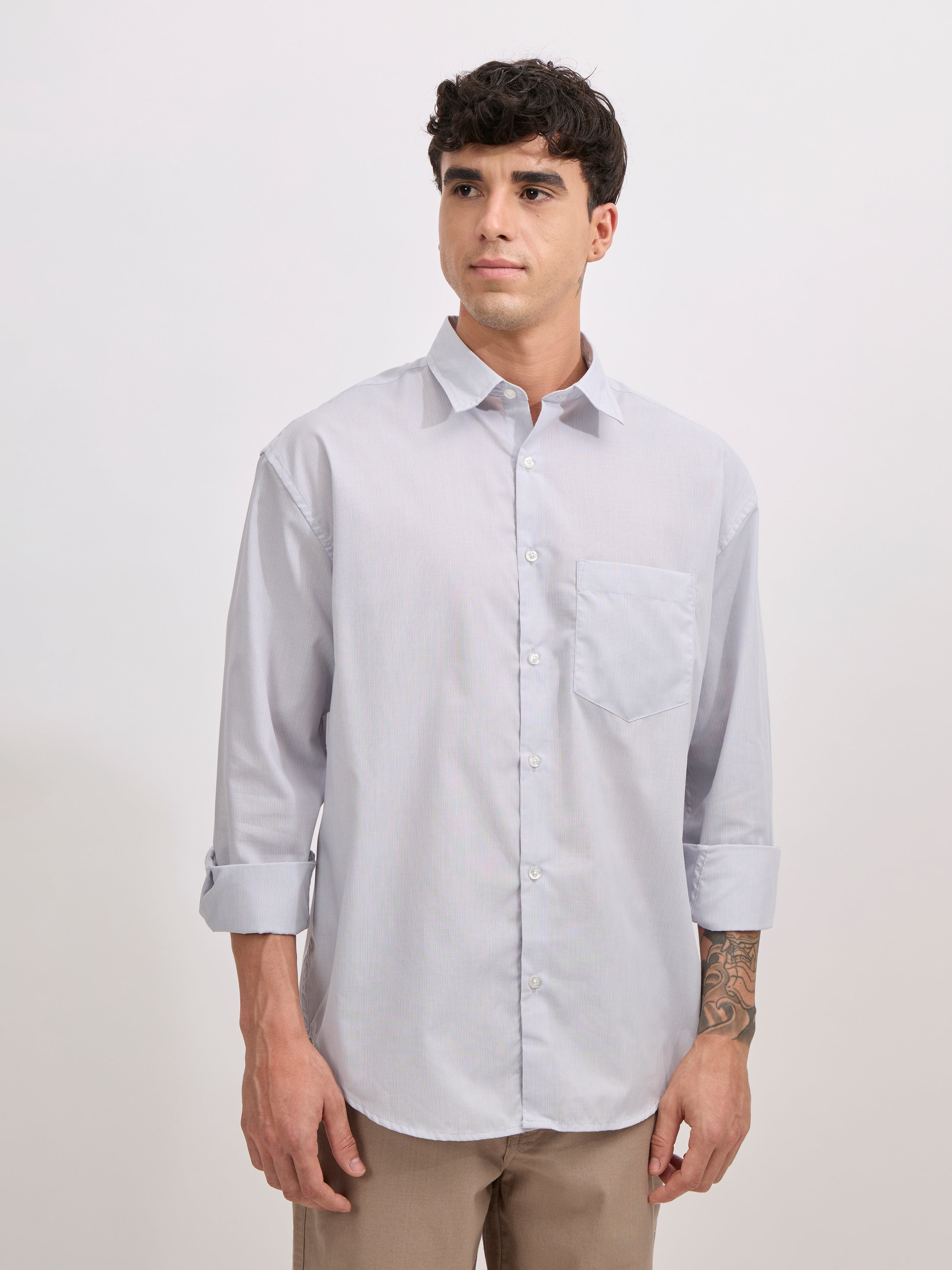 Man wearing grey cotton oversized striped shirt with rolled sleeves, front pocket, and button-down collar
100% cotton

