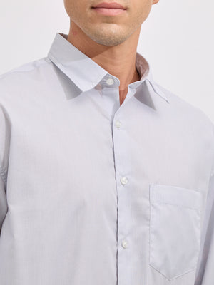 Man wearing grey cotton oversized striped shirt with rolled sleeves, front pocket, and button-down collar
100% cotton
