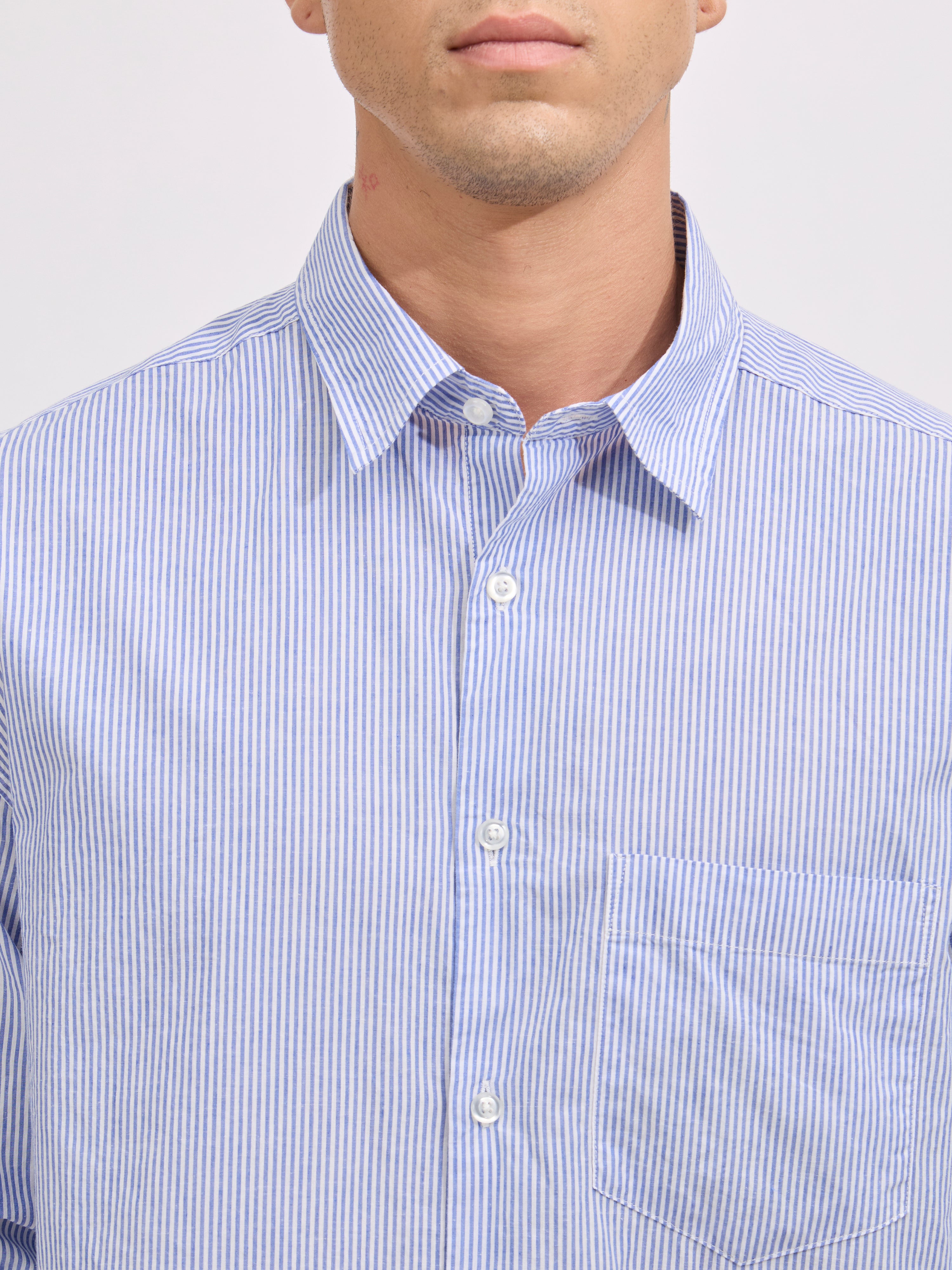 Man wearing sky blue cotton oversized striped shirt with rolled sleeves, front pocket, and button-down collar
100% cotton
