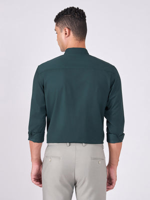 Man wearing Tencel  prussian blue shirt and light gray pants on a white background