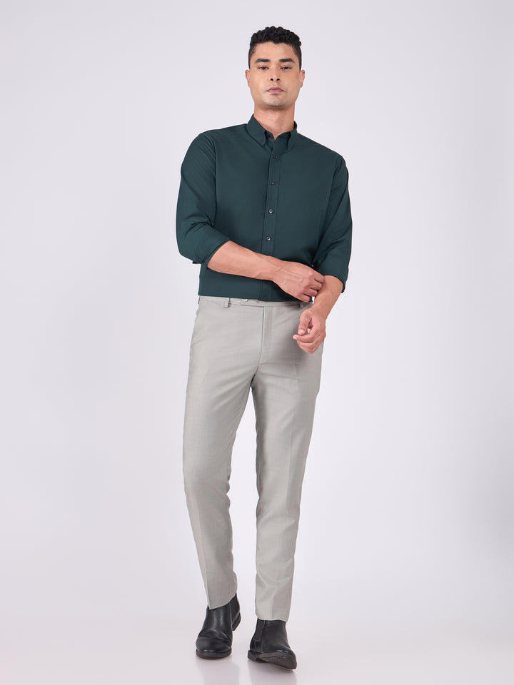 Man wearing Tencel  prussian blue shirt and light gray pants on a white background