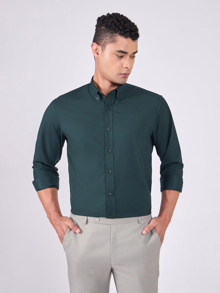 Man wearing Tencel  prussian blue shirt and light gray pants on a white background