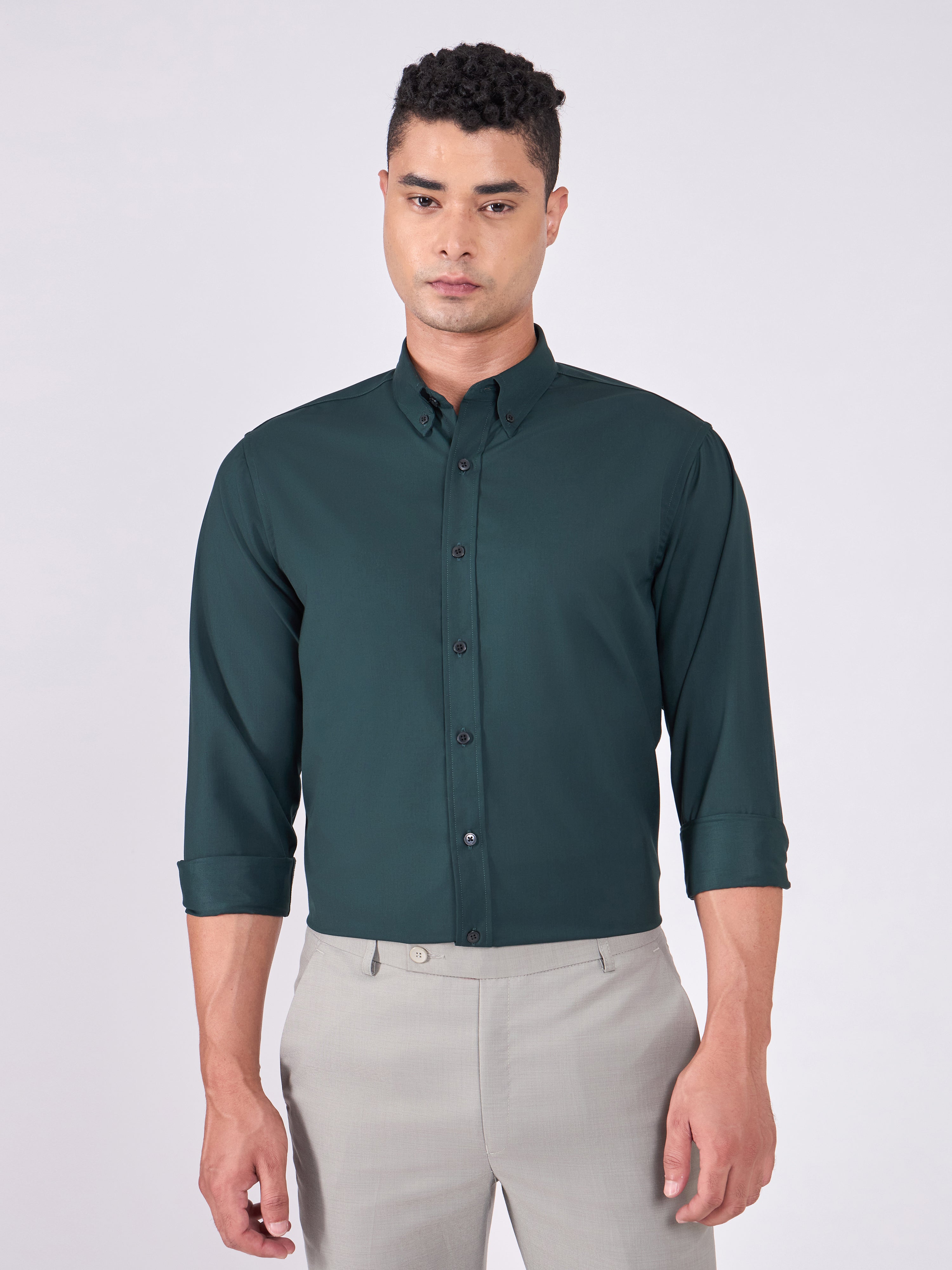 Man wearing Tencel  prussian blue shirt and light gray pants on a white background