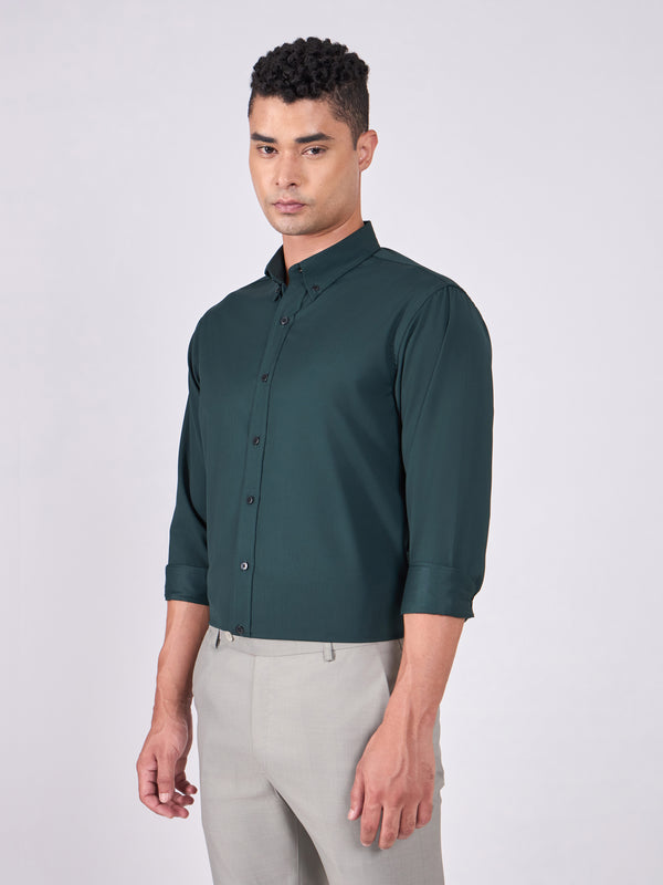 Man wearing Tencel  prussian blue shirt and light gray pants on a white background