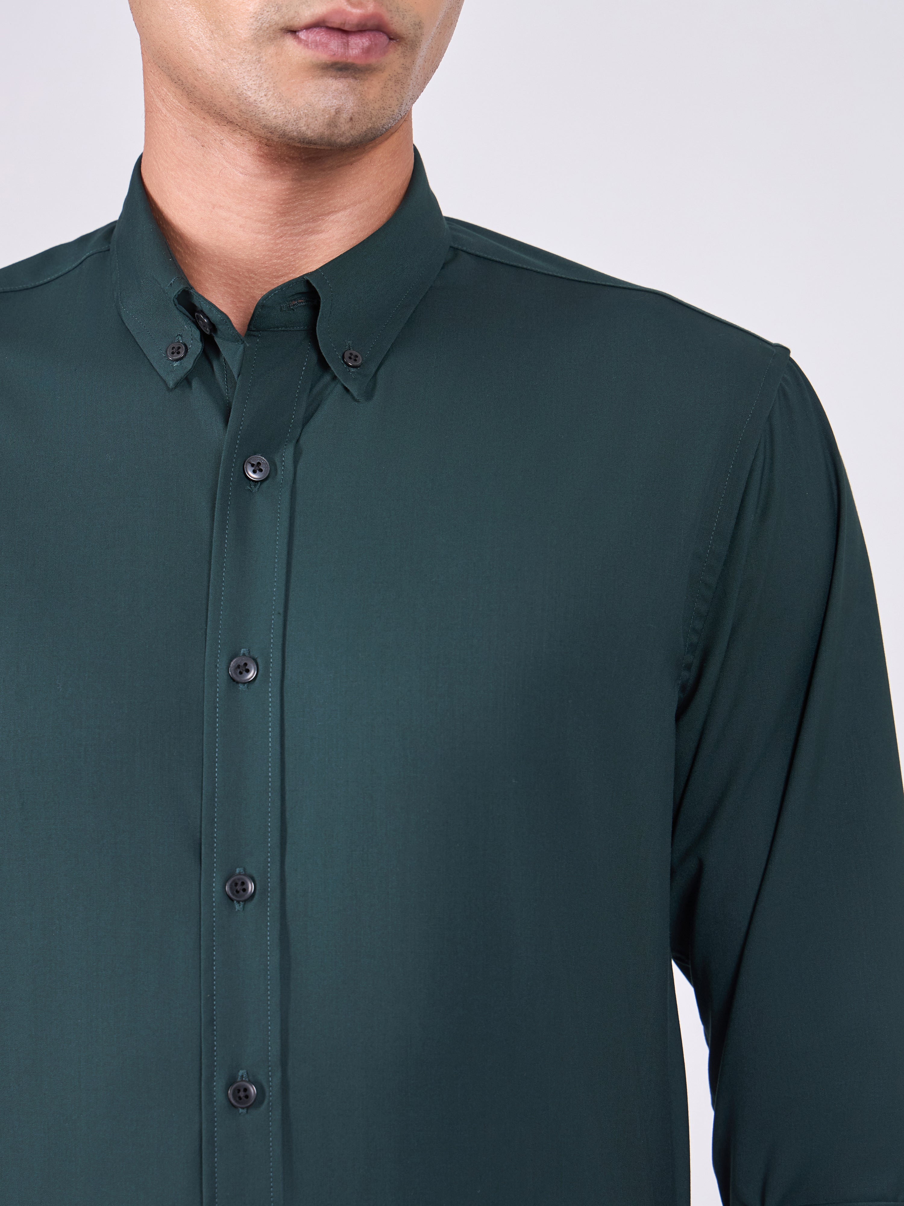 Man wearing Tencel  prussian blue shirt and light gray pants on a white background