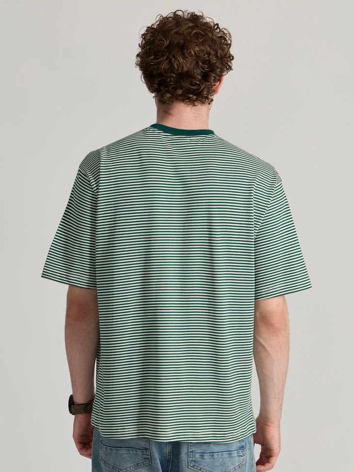 Man wearing a green  and white striped crew t-shirt 
