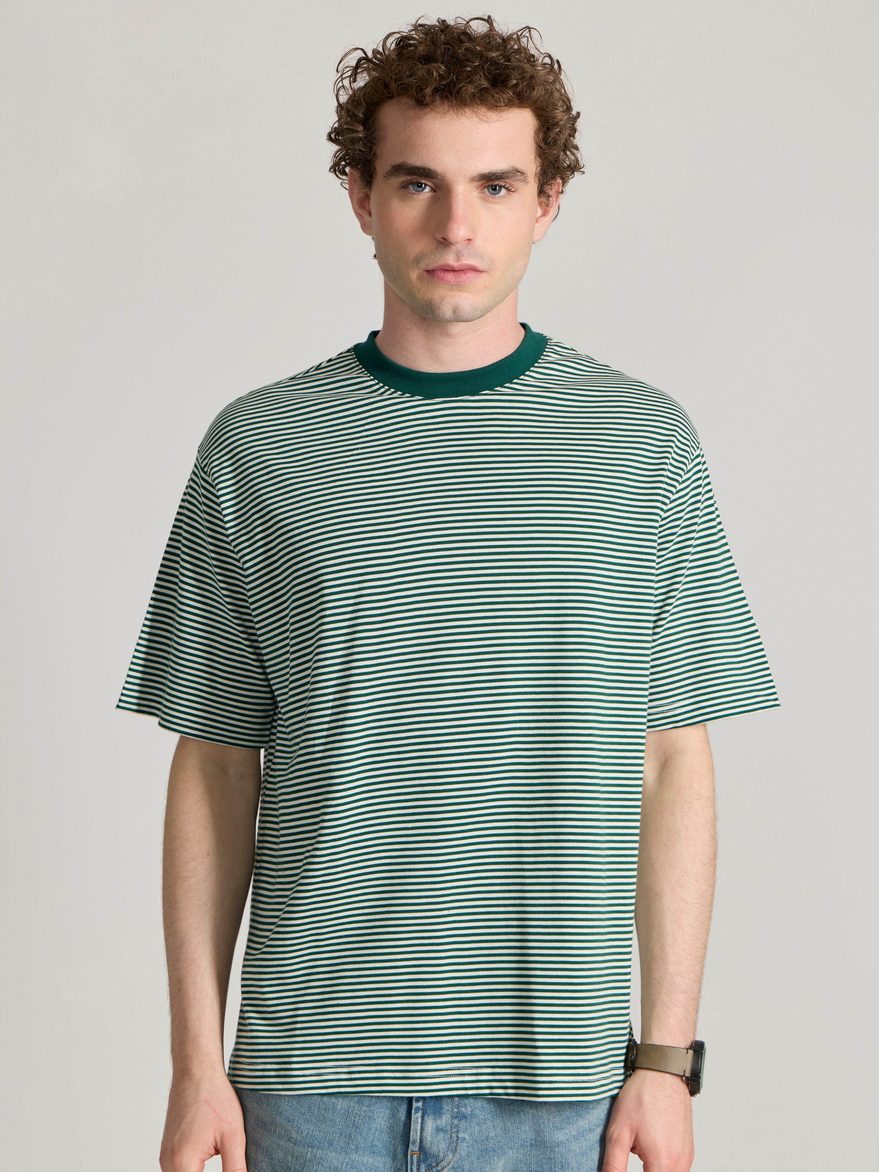 Man wearing a green  and white striped crew t-shirt 
