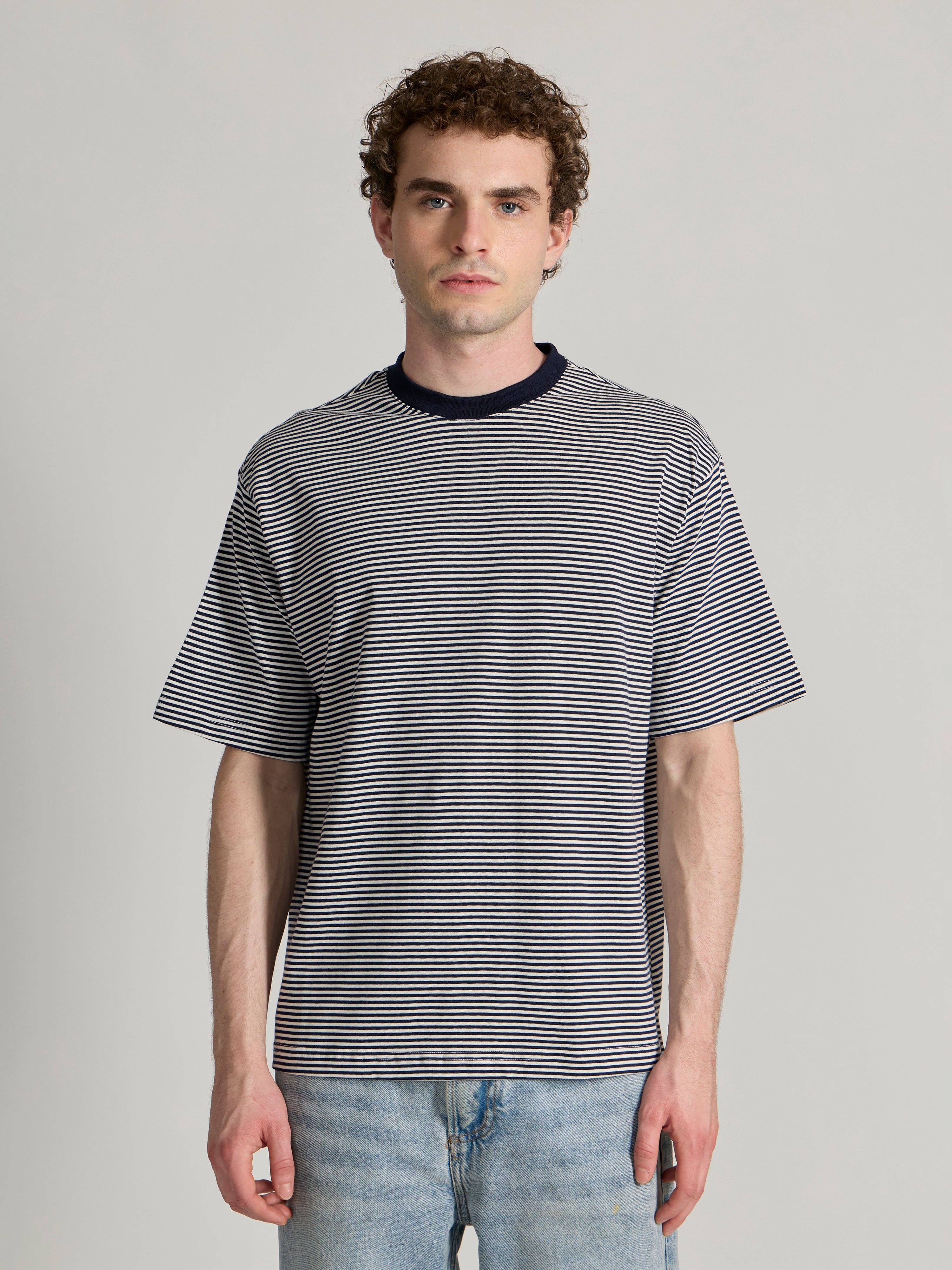 Man wearing a navy blue striped crew t-shirt 
