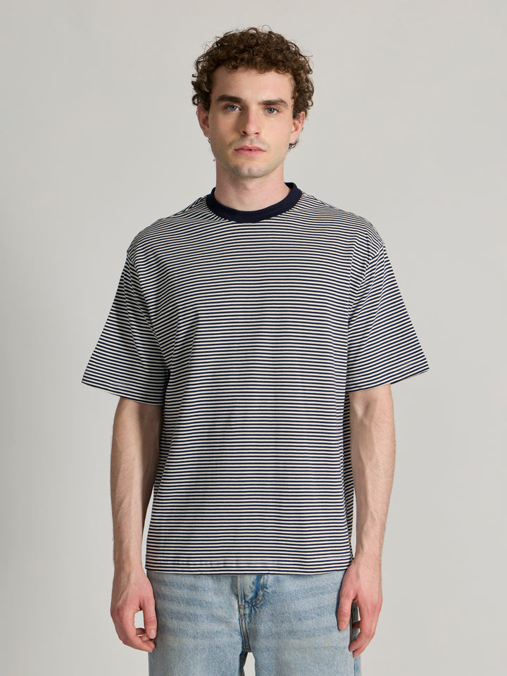 Man wearing a navy blue striped crew t-shirt 
