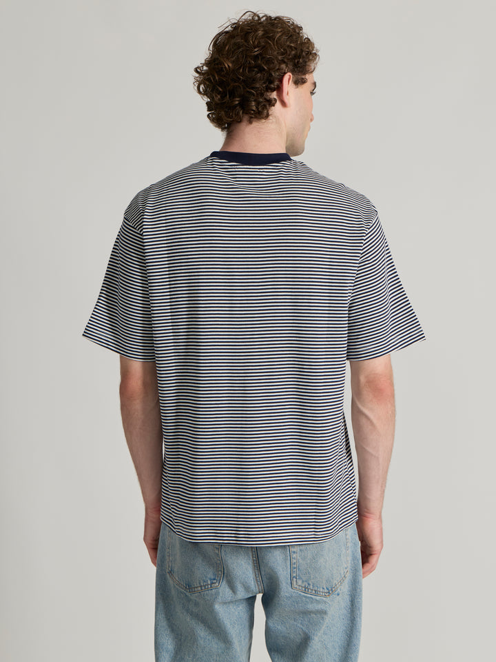 Man wearing a navy blue striped crew t-shirt 
