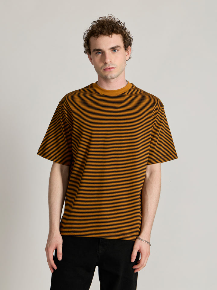 Man wearing a mustard yellow and black striped crew t-shirt 
